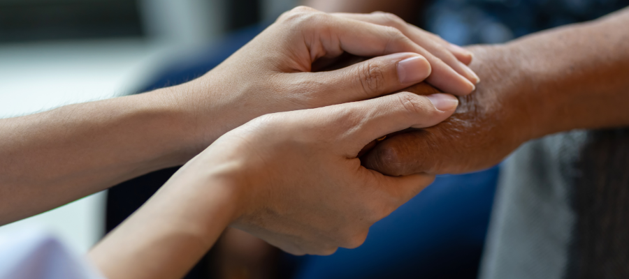 Close up of two people clasping hands