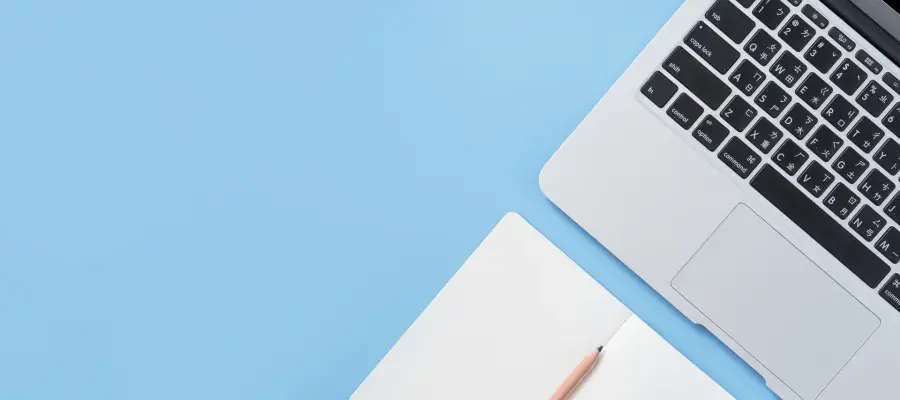 Blue background, close up of laptop and notebook