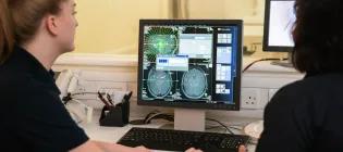 Two women sitting at a computer screen