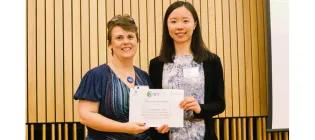 Chen Zhao is presented with her winning Three Minute Thesis certificate